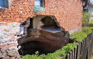 A sinkhole at the foot of the house after the earthquake